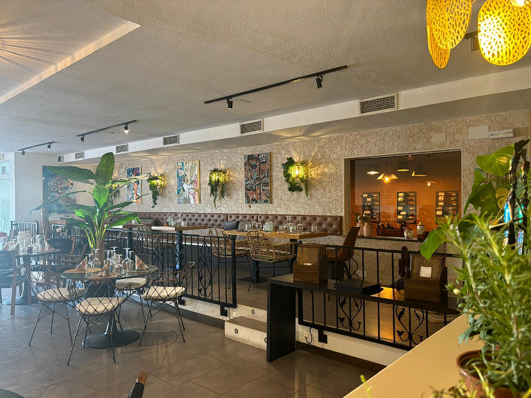 Salón del restaurante Royal Blossom con plantas y luz cálida